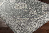 Close-up of the Macgregor Area Rug showing its charcoal base and light gray, hand-loomed, bohemian-inspired pattern and texture. Corner