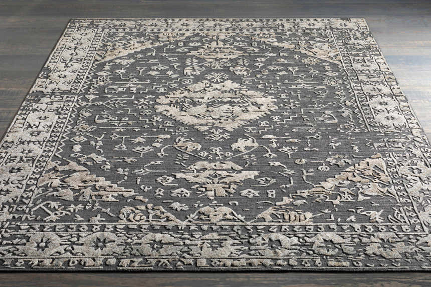 Close-up of the Macgregor Area Rug. Charcoal gray rug with a light gray, hand-loomed, bohemian-inspired pattern. Styleshot