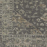 Close-up of the Macgregor Area Rug in charcoal, light gray, and olive. Bohemian style with traditional floral and geometric patterns. Swatch