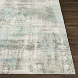 Close-up of the Machen Area Rug. Beige, ice blue, and gray contemporary design on a hand-knotted wool and viscose rug. Front