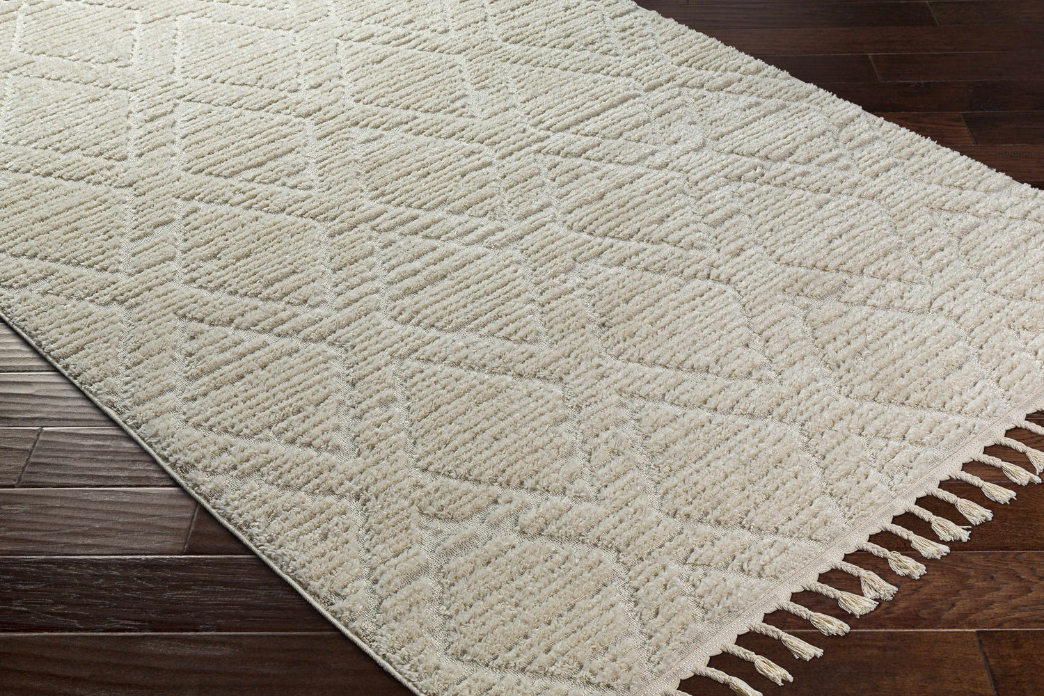 Close-up of bone Maduao Area Rug showing geometric pattern and soft texture on dark wood floor. Clearance item. Corner