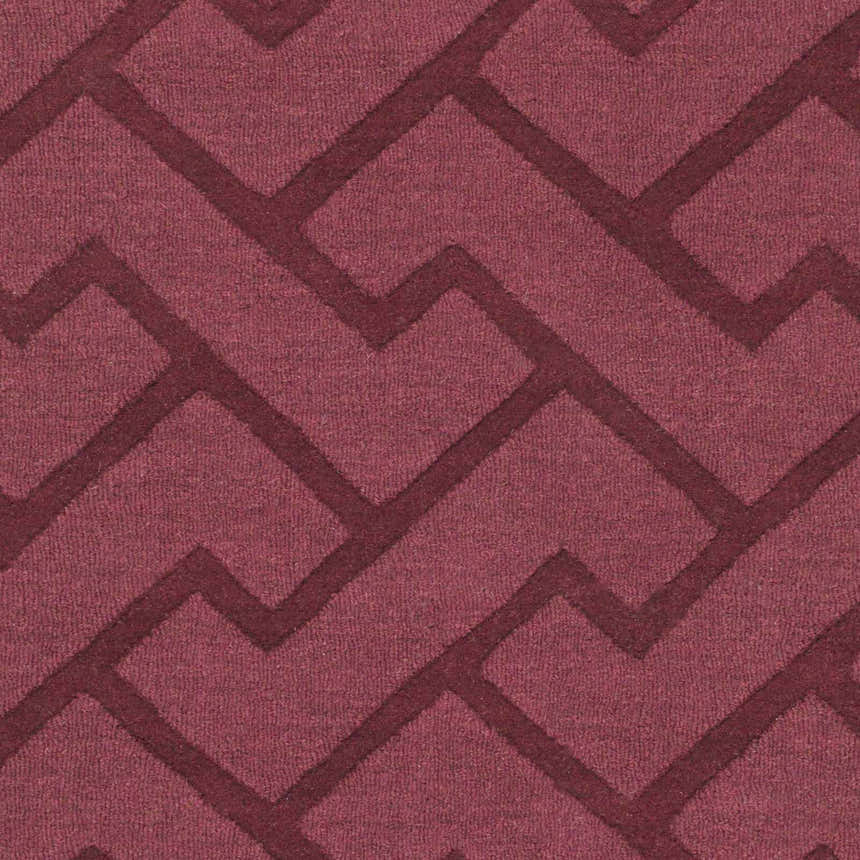 Close-up of the Magness Area Rug showing its plum color and contemporary geometric design. 100% wool texture. Swatch