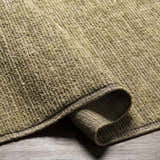 Close-up of the hand-loomed Magpet Area Rug. Olive green 100% wool rug with a textured, contemporary design. Fold