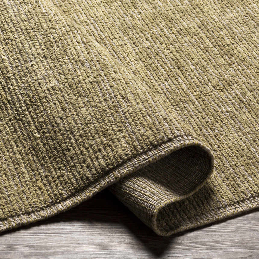 Close-up of the hand-loomed Magpet Area Rug. Olive green 100% wool rug with a textured, contemporary design. Fold