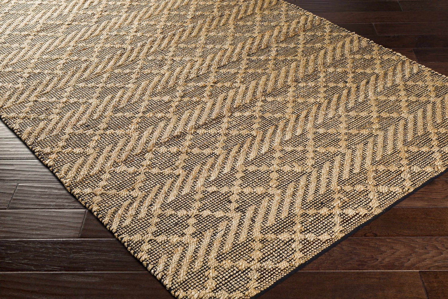 Close-up of the tan and black geometric pattern on the hand-woven Malidong Jute Carpet. Corner