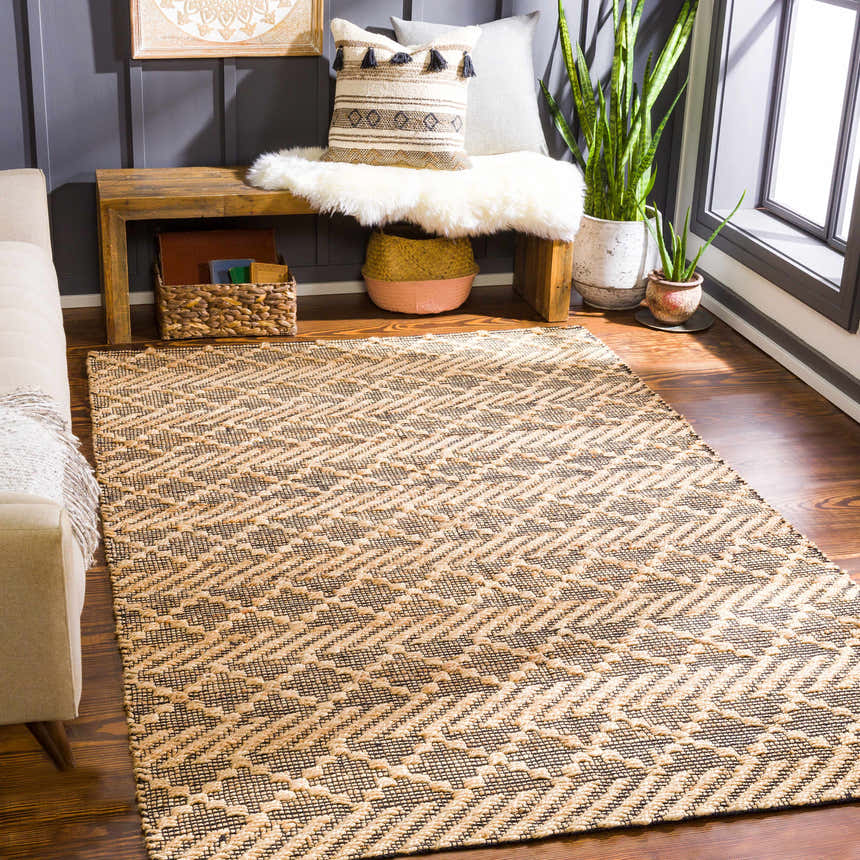 Living room scene with a tan sofa and the Malidong Jute Carpet in black and tan with a geometric pattern. Roomscene-Rectangle