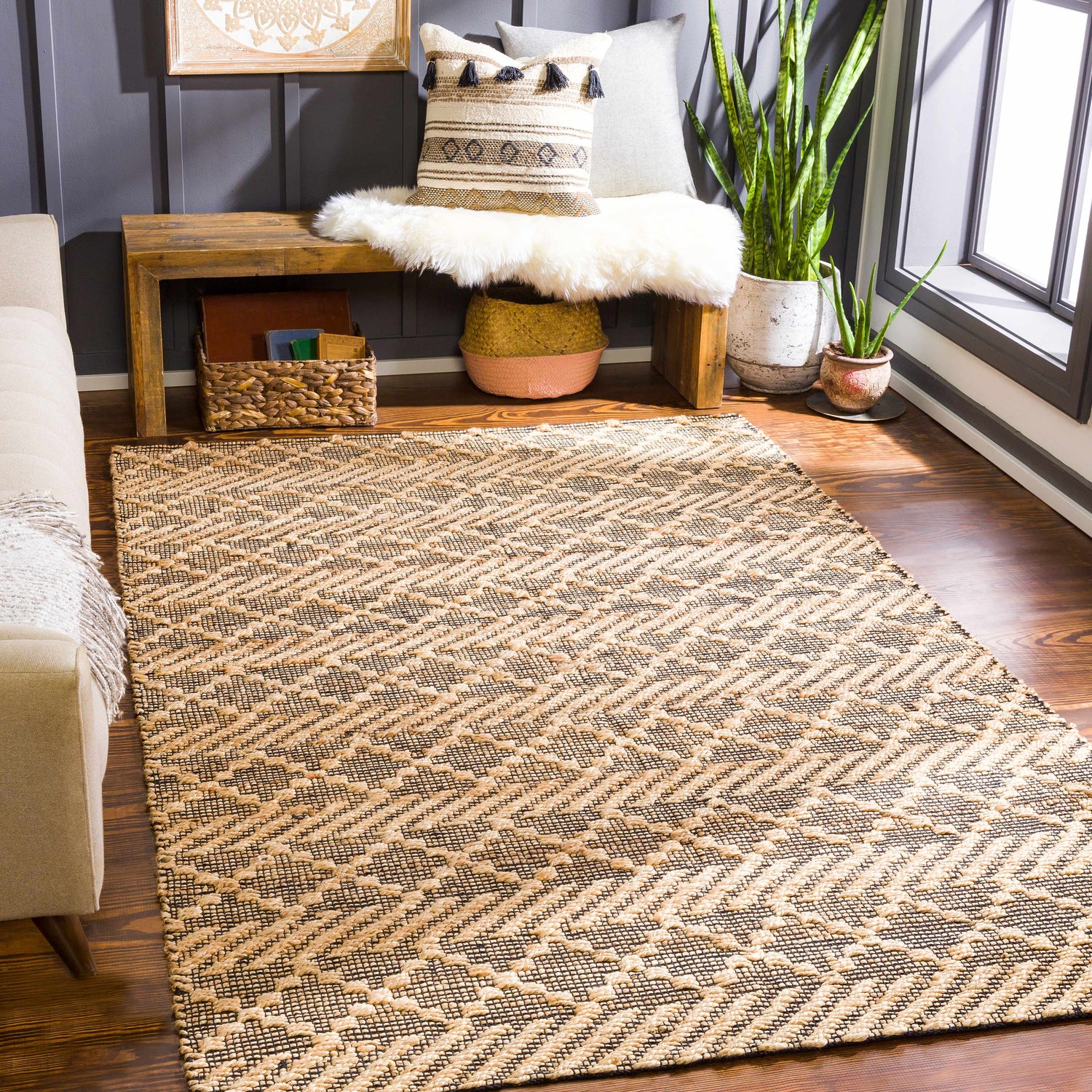 Living room scene with a tan sofa and the Malidong Jute Carpet in black and tan with a geometric pattern. Roomscene-Rectangle