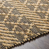 Close-up of the hand woven Malidong Jute Carpet. Black and tan geometric pattern with a textured, bohemian style. Texture