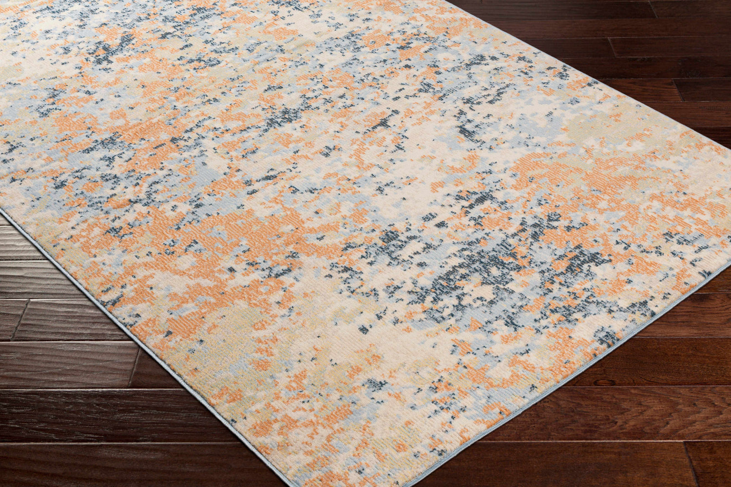 Close-up of Mallow Area Carpet in beachhouse, camel, and dark gray on dark wood floor. Contemporary designer rug. Corner