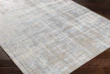 Close-up of the Manzanita Area Rug. Contemporary design in blue, cream, and taupe on dark wood floors. Corner
