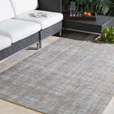 Outdoor patio scene with a blue and cream Manzanita Area Rug, wicker furniture, and neutral tile flooring. Roomscene-Rectangle