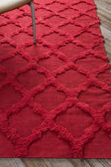 Close-up of the red Marilla Area Rug, a hand-woven wool shag rug with a diamond trellis pattern. Styleshot