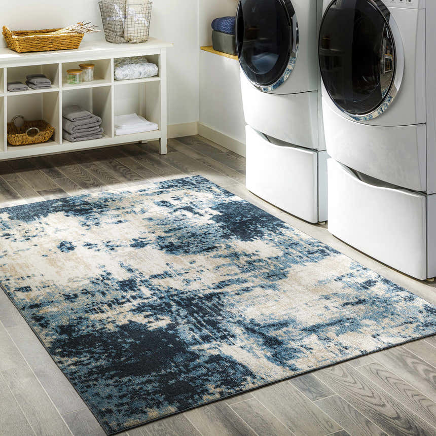 Laundry room with white washer/dryer and blue Masiga Washable Area Rug on gray wood floor. Roomscene-Rectangle