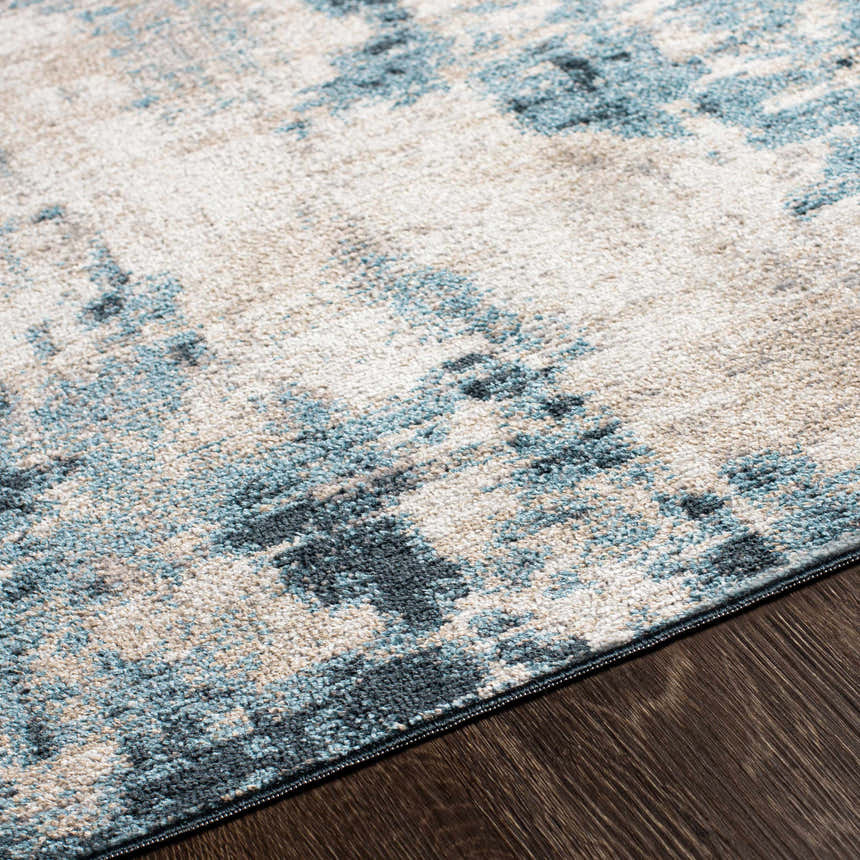 Close-up of the Masiga Washable Area Rug showing its contemporary blue, gray, and beige abstract pattern and soft texture. Texture