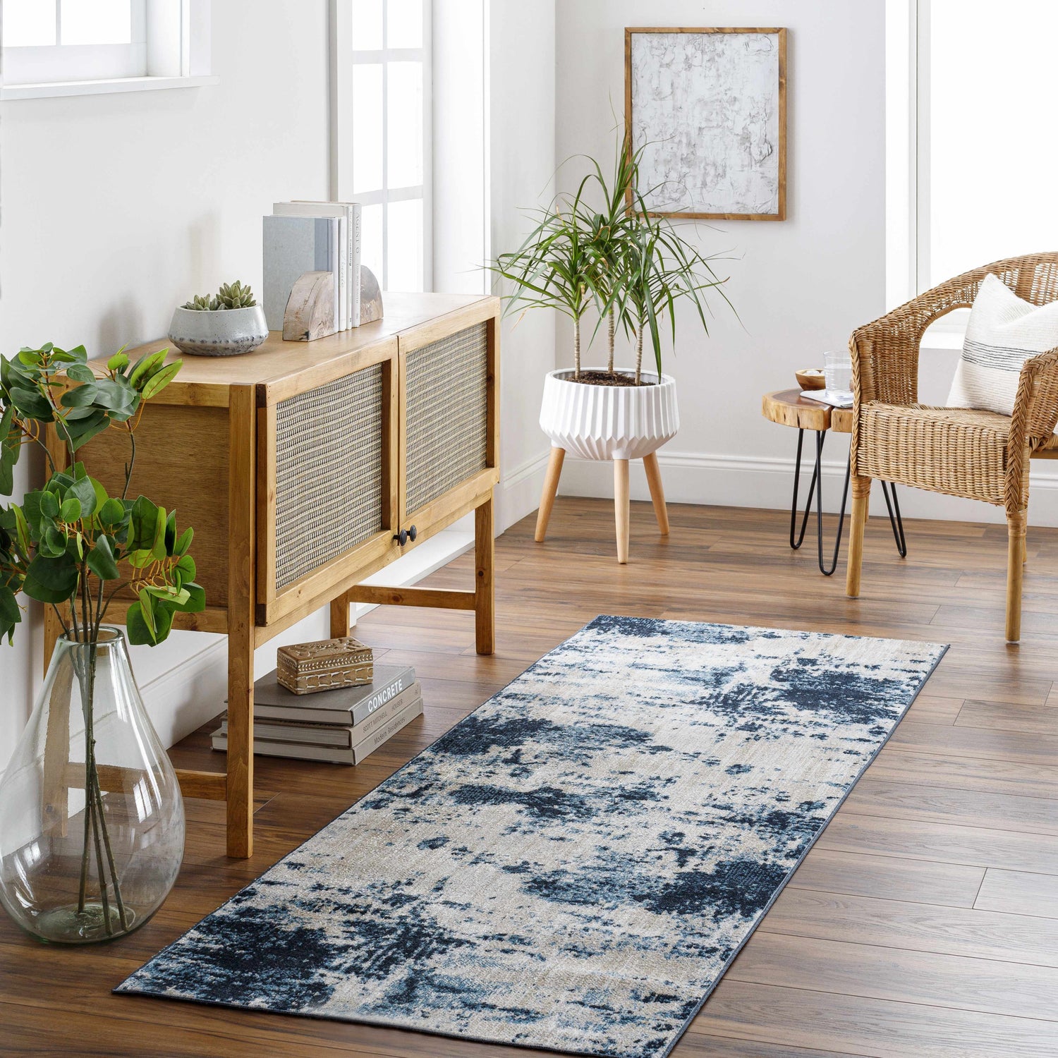 Entryway with a blue and beige Masiga Washable Area Rug, wooden console table, wicker chair, and wood floors. Roomscene-Runner