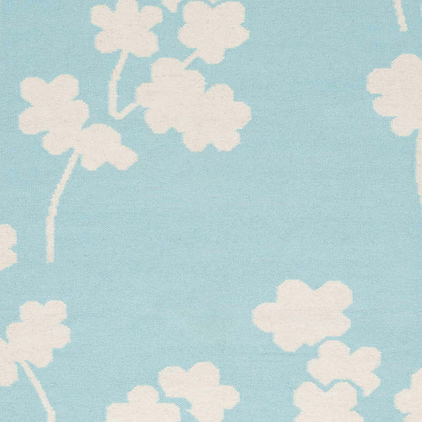 Close-up of the Matador Area Carpet. Aqua background with a light beige floral pattern. Hand woven wool rug. Swatch