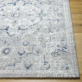 Close-up of the Mateo Area Rug, a light gray traditional rug with a pale slate and silver pattern on wood flooring. Front