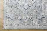 Close-up of the Mateo Area Rug, showcasing its light gray, silver, and pale slate traditional design. Corner