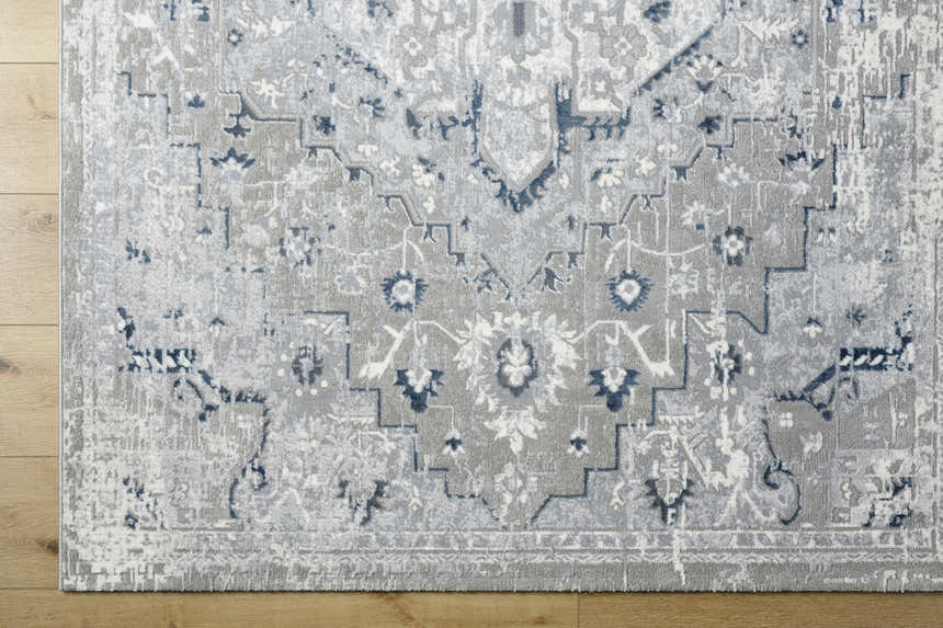 Close-up of the Mateo Area Rug, showcasing its light gray, silver, and pale slate traditional design. Corner