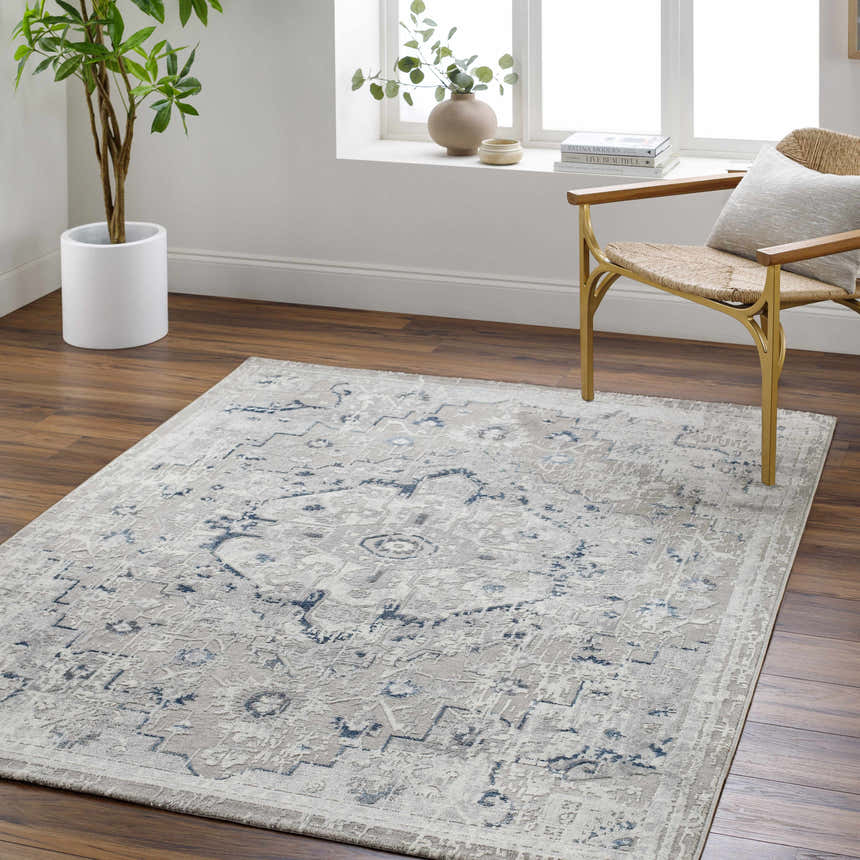 Light gray Mateo Area Rug in a bright living room with wood floors, a woven chair, and a potted plant. Roomscene-Rectangle