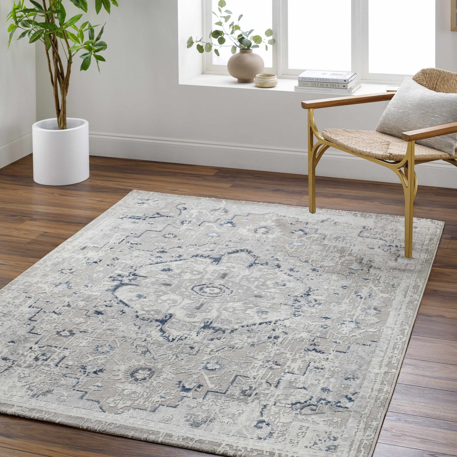 Light gray Mateo Area Rug in a bright living room with wood floors, a woven chair, and a potted plant. Roomscene-Rectangle