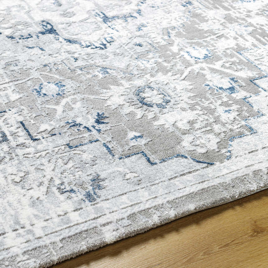 Close-up of the Mateo Area Rug, showcasing its light gray, silver, and blue traditional design and soft texture. Texture