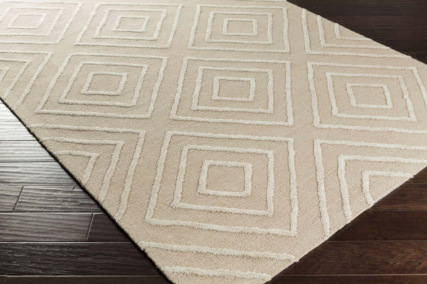 Close-up of the beige Maytown Area Rug, featuring a contemporary geometric square pattern, hand-tufted texture, and cotton material. Corner