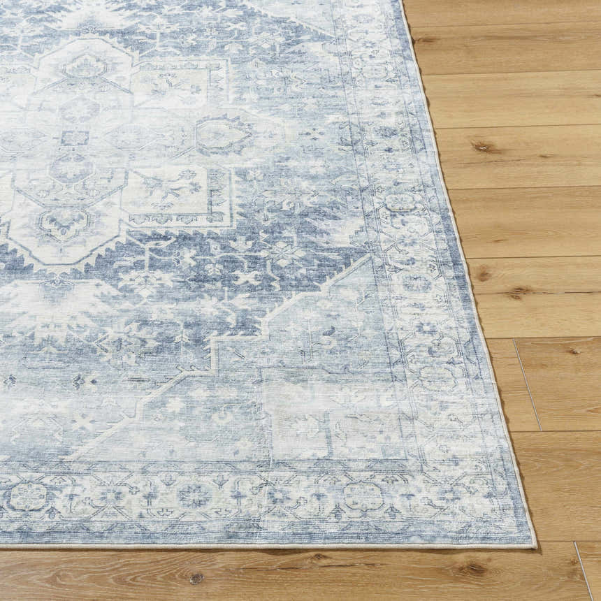 Close-up of the Mauro Navy Medallion Washable Area Rug showing its blue and gray traditional design and soft texture. Front