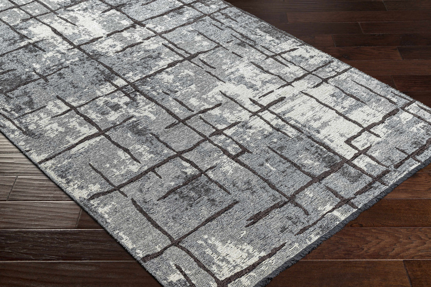 Close-up of Mace Area Rug: charcoal, cream, and slate geometric pattern on a chenille-polyester rug with a mid-century modern design. Corner