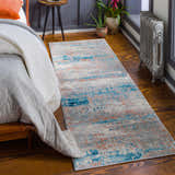 Bedroom scene with McCracken Area Rug runner in blue and orange, laid on wood floor near bed and radiator. Roomscene-Runner