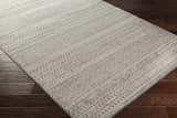 Close up of the Mckinney Area Rug showing its charcoal, light beige, and medium gray contemporary pattern. Corner