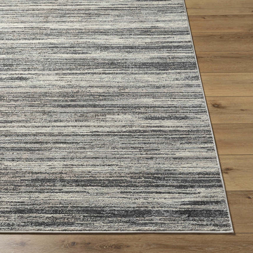 Close-up of Munya Area Rug showing charcoal, cream, and gray horizontal stripes on a wood floor. Southwestern style. Front