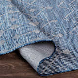 Close up of the Maddingley Flatweave Area Carpet in blue and dark blue, showing the contemporary woven texture. Fold