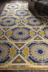 Close-up of the Mesena Area Rug. Ivory wool rug with a geometric pattern in light gray, navy, and tan. Hand-knotted construction. Styleshot