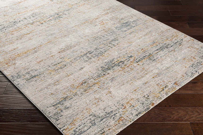 Close-up of the Midhurst Luxe Rug. Contemporary style rug in cream, gray, and mustard on dark wood flooring. Corner