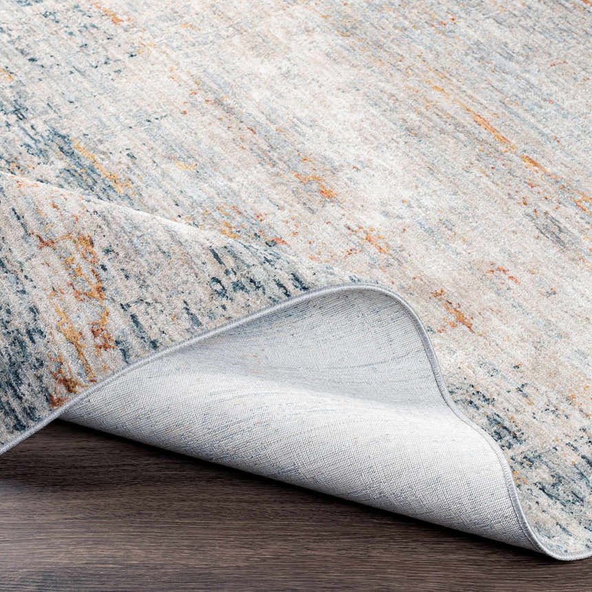 Close-up of the Midhurst Luxe Rug showing its cream, blue, and orange contemporary pattern and woven texture. Fold