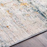 Close-up of the Midhurst Luxe Rug. Contemporary design with brick red, cream, dusty sage, gray, mustard, and teal colors. Texture