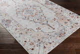 Close-up of the Midtown Washable Area Rug. Features a traditional oriental pattern in brick red, charcoal, gray, and peach. Corner