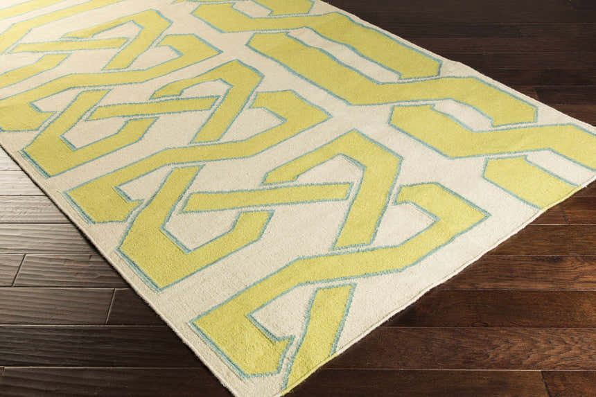 Close-up of Milano Area Rug: ivory wool rug with a light olive and seafoam geometric pattern. Hand woven. Corner