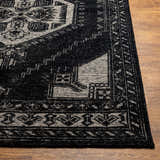 Close-up of the hand-knotted Minapan Premium Area Rug. Black and cream traditional oriental rug pattern on wood floor. Front