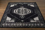 Close-up of the Minapan Premium Area Rug. Black and cream traditional rug with an oriental pattern on a wood floor. Front