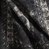 Close-up of the hand-knotted Minapan Premium Area Rug. Black and cream cotton and wool rug with a traditional oriental pattern. Fold