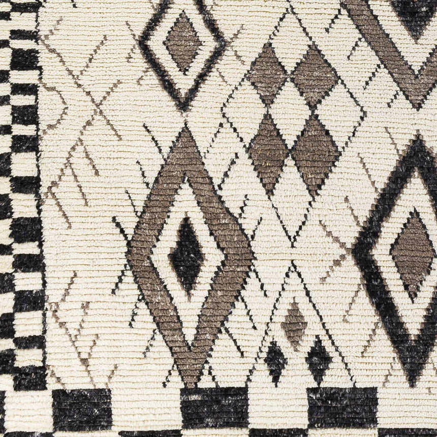 Close-up of the Minyama Area Rug showing its cream base and black and charcoal geometric diamond pattern. Swatch