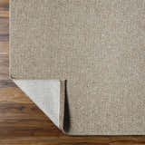 Close-up of the beige Matah Outdoor Area Rug showing its woven texture and light brown tones on a wood floor. Fold