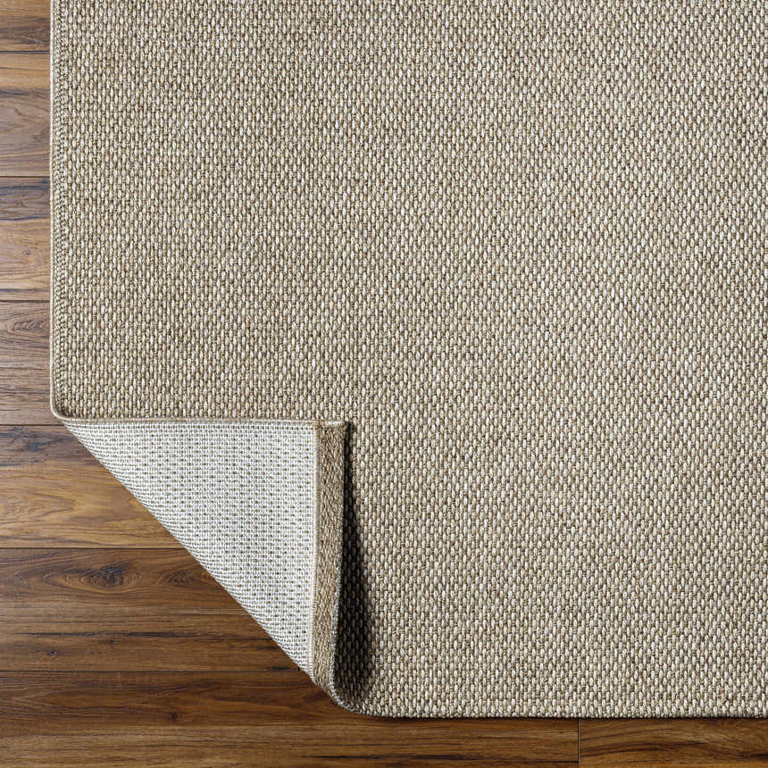 Close-up of the beige Matah Outdoor Area Rug showing its woven texture and light brown tones on a wood floor. Fold