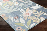 Close-up of Micha Area Rug with blue background, floral and jaguar design in cream, mustard, olive, and rust. Corner