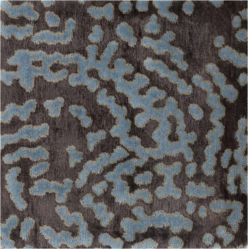 Close-up of the Pensacola Denim/Black rug. Abstract denim blue pattern on a dark charcoal background. Hand-knotted wool and viscose texture. Swatch