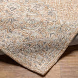 Close-up of the hand-tufted Modimolle Area Carpet. Features a traditional Persian-style design in brown, camel, and gray tones. Fold