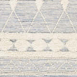 Close-up of the Moe Area Rug showing its hand woven texture and bohemian blue, cream, and white pattern. Swatch
