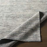 Close-up of the hand-knotted Molena Area Rug. Denim, ink blue, light olive, and light sage wool rug with a contemporary design. Front